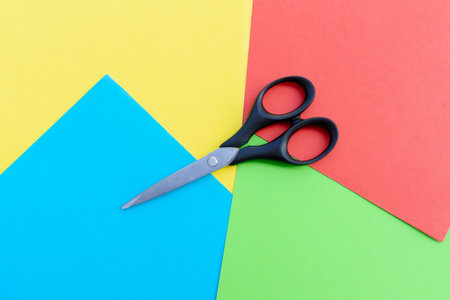 Scissors placed on colored papers, after some edits.の写真素材