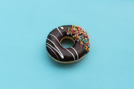 Messy chocolate doughnut isolated on blue background, after some edits.の写真素材