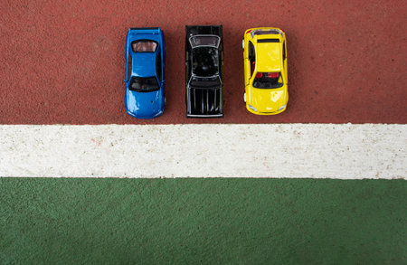 Concept for racing. After some edits, a photo of 3 toy cars placed at the edge of the court line.の写真素材