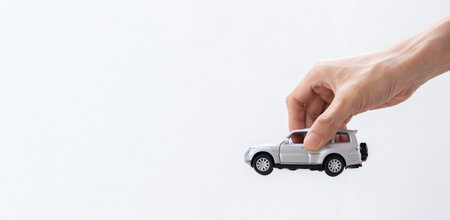 Hand holding a toy car isolated on gradient background. After some edits.の写真素材
