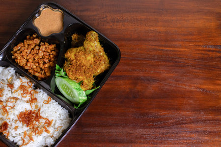 Indonesian meal box called uduk placed on the wooden table. After some edits.の写真素材