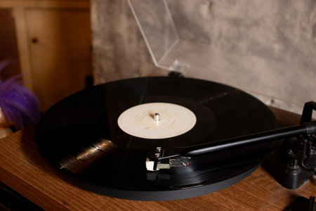 Vintage turntable with vinyl record on a wooden table. After edits.の写真素材