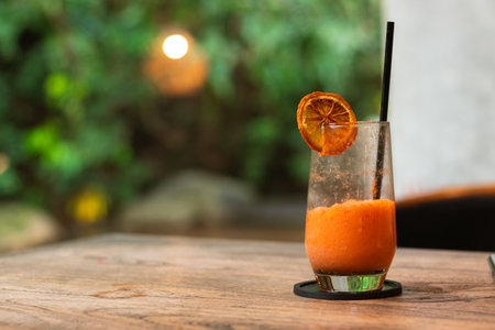 Mixed juice of orange and carrot, on a wooden table with garden background. After edits.の写真素材
