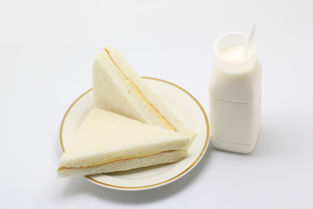 sandwich and bottle of milk with white drinking strawの写真素材