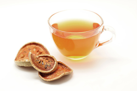 hot bael juice and dried bael fruit isolated on white backgroundの写真素材