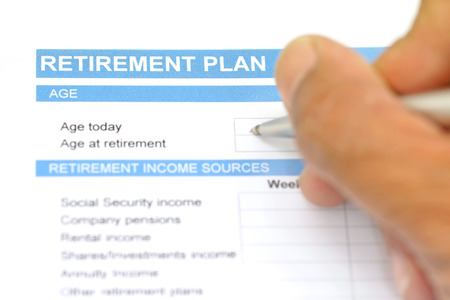 retirement plan document with pen and human handの写真素材