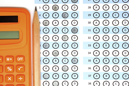 answer sheet test score with pencil and orange calculator