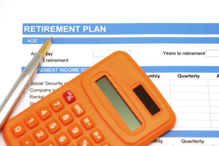 retirement plan document with pen and orange calculatorの写真素材
