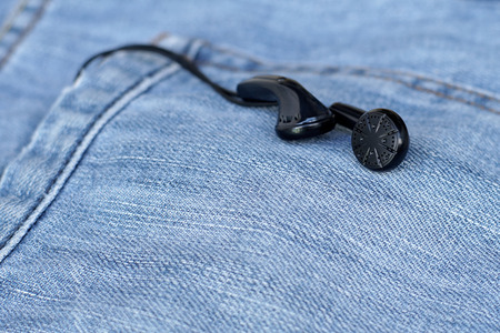 black earbuds in back pocket old jeansの写真素材