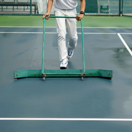 cleaning crew drying tennis court after rainの写真素材