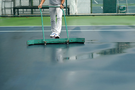cleaning crew drying tennis court after rainの写真素材
