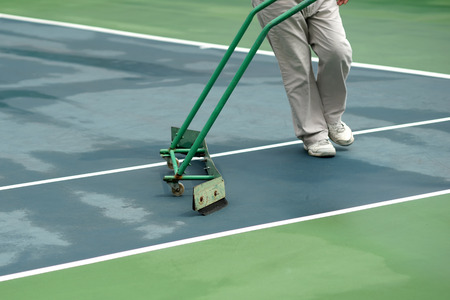 cleaning crew drying tennis court after rainの写真素材