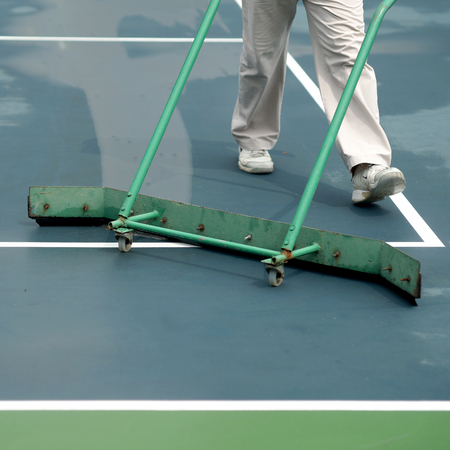 cleaning crew drying tennis court after rainの写真素材
