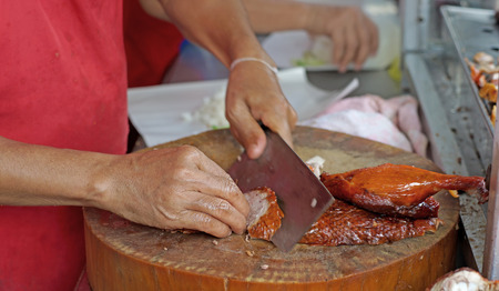 chef slicing roast duck on a cutting boardの写真素材