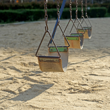empty old chain swings in kids playgroundの写真素材