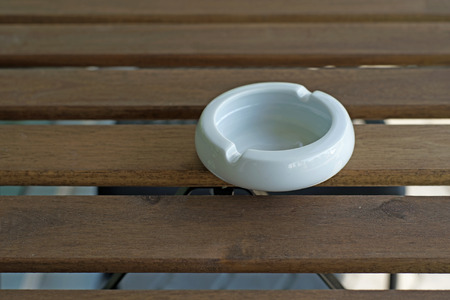 empty white ashtray on a wooden tableの写真素材