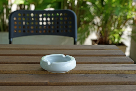 empty white ashtray on a wooden tableの写真素材