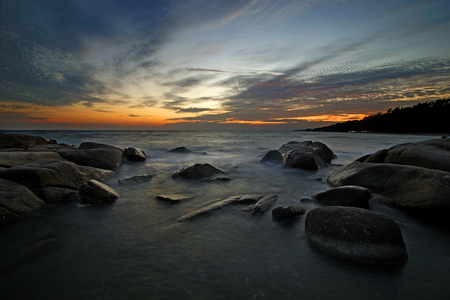 beautiful sunset over the sea mist on rocksの写真素材
