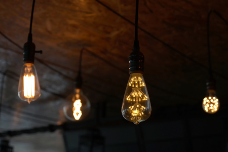 decorative antique tungsten light bulbs hanging on ceilingの写真素材
