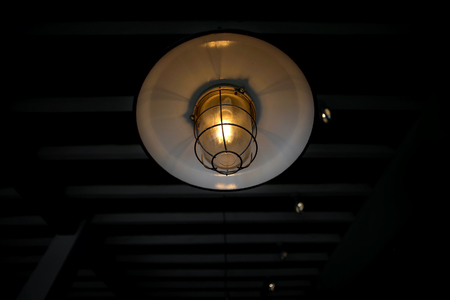 old hanging lamp with light bulbs in dark roomの写真素材