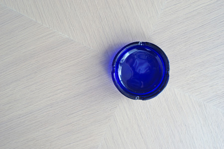 empty blue ashtray on a wooden tableの写真素材