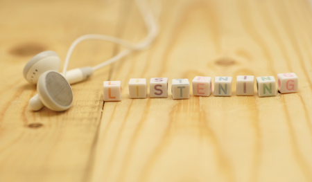 white earbuds with alphabet listening on cube shapeの写真素材
