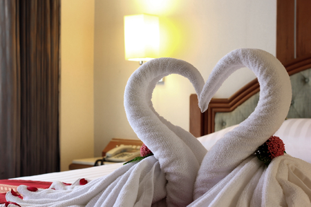 heart shaped of towel on the bedの写真素材