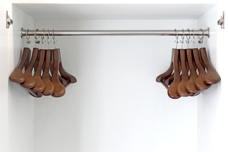 wooden hangers on a rod in wardrobeの写真素材