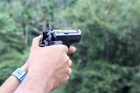 gun in man hand over blurry background