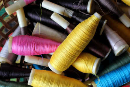 colorful bobbins of thread in basketの写真素材