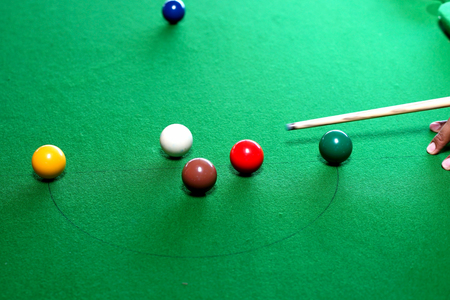 snooker game situation with the snooker player being ready to hit the white ball