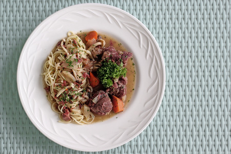 delicious italian spaghetti with pork bone on wooden tableの写真素材
