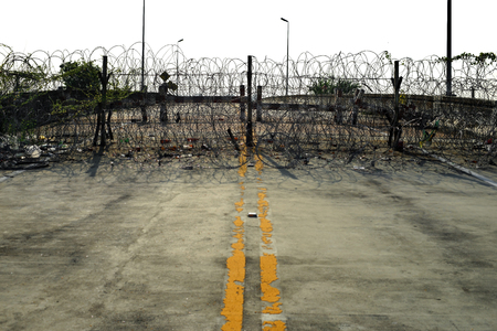 barbed tape or razor wire cross the roadの写真素材