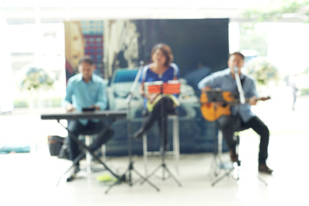 blurry photo of trio band with a guitar piano and singing の写真素材