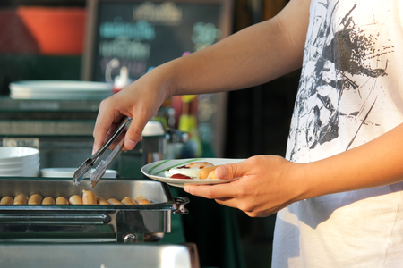 customer scooping the food in buffet line for breakfast mealの写真素材