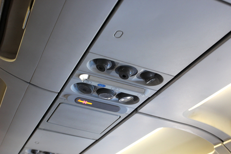 closeup of air grille diffuser and lamp on ceiling  in the airplaneの写真素材