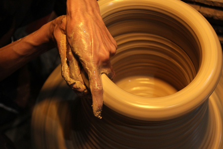 closeup of hands making pottery on pottery wheelの写真素材