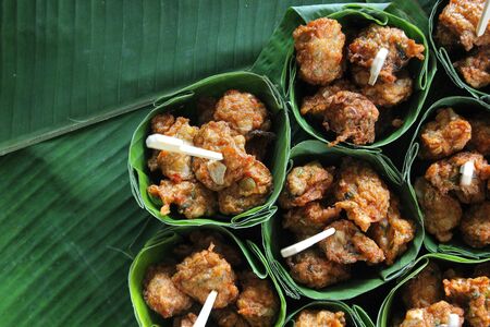 thai food, fried fish-paste balls in banana leaves on buffet lineの写真素材