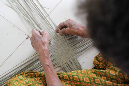 The villager took bamboo stripes to weaving basket