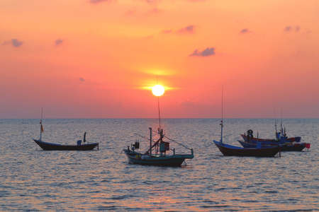 fishing boat in the sea with beautiful sunset backgroundの写真素材