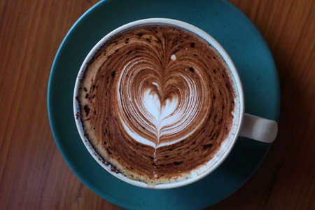cup of hot latte art coffee on wooden tableの写真素材