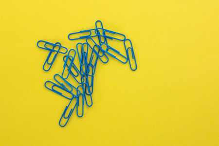 blue paper clips on a yellow background