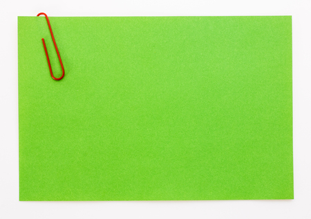 green sheet of paper with a red clipの写真素材
