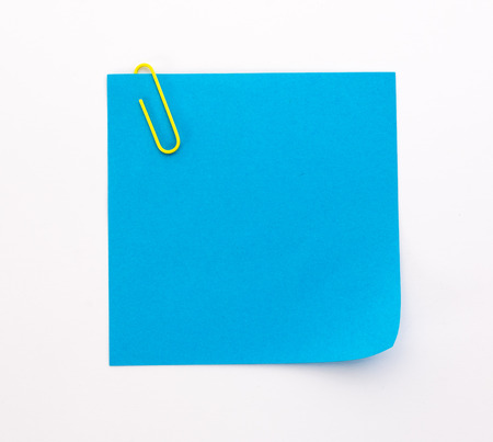 blue sheet of paper with yellow paper clip on a white backgroundの写真素材