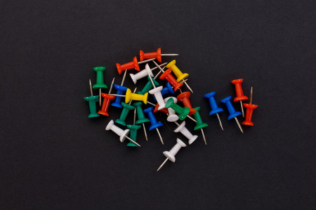 colored push pins on a black backgroundの写真素材