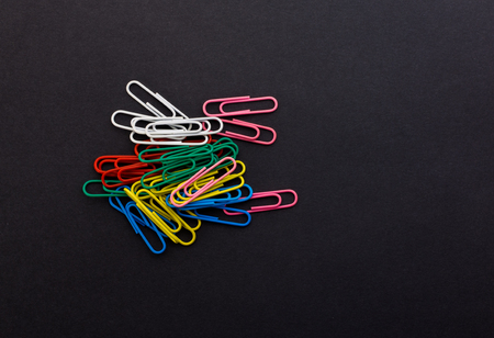 colored paper clips on a black backgroundの写真素材