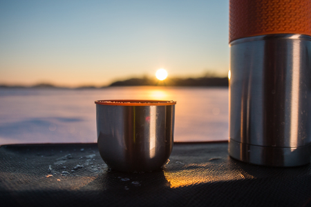 cup from bottle at sunsetの写真素材
