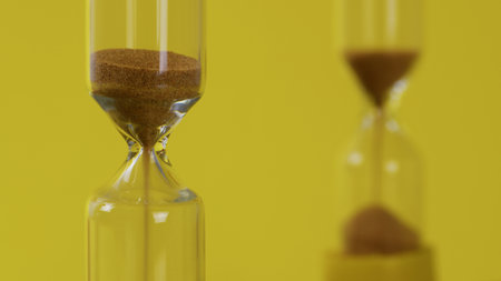 Sandglasses On A Yellow Backgroundの写真素材