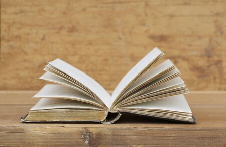 Old book on wooden shelf.