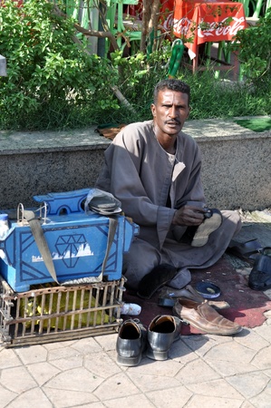 Egypt, Aswan - on September, 21st 2010: the Egyptian man, the cleaner of footwear in a peace life in streets of the city of Aswanのeditorial素材